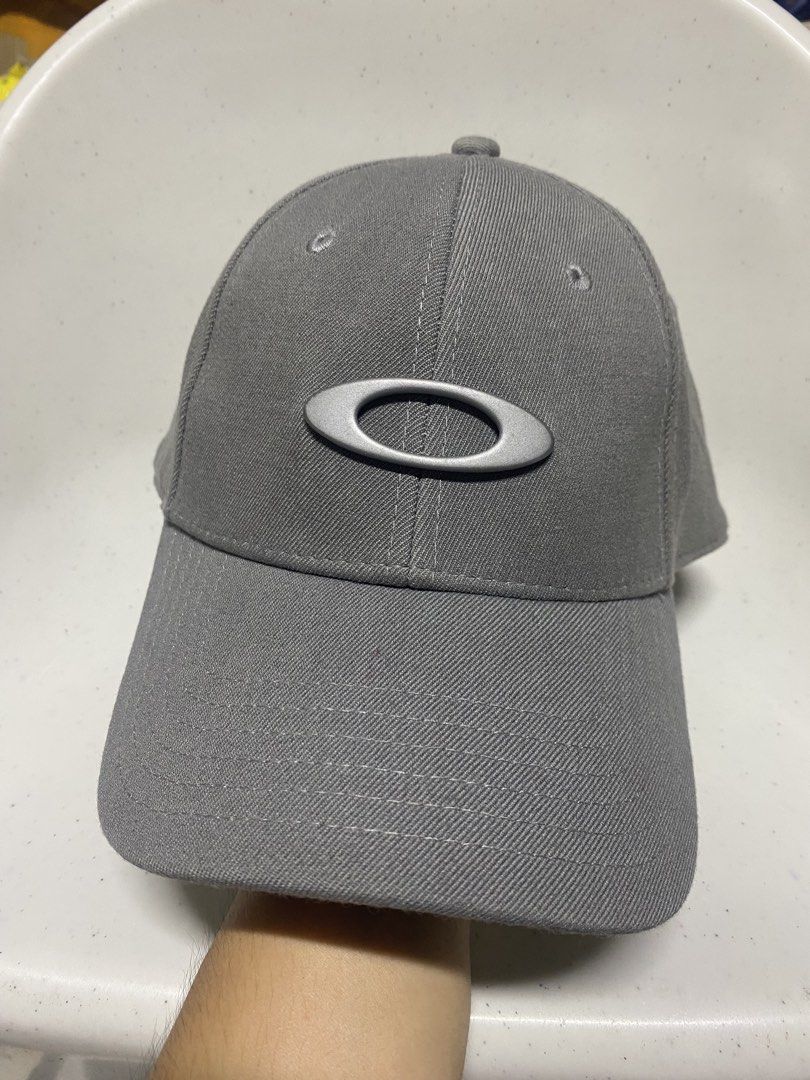 Oakley Classic Low A-Flex Cap Grey L/XL (Category: Caps & Hats) located in Pasacao. Submitted by wengpullar37205 (Listing ID 1466482952, Image 1). Description: - Brand: Oakley - Color: Grey with silver metal ellipse logo on front and black embroidered branding on back - Size: L/XL (A-Flex stretch-fit design) - Material: Comfortable acrylic, wool, and elastane blend - Design: Structured crown, curved brim, and branded interior taping - Condition: 