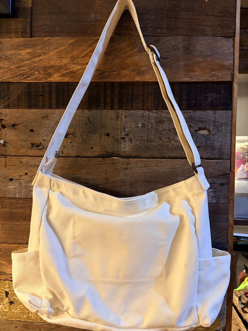 Off-White Canvas Crossbody Bag with Multiple Pockets (Category: Cross-body Bags) located in Quezon City. Submitted by makingroomfinds (Listing ID 1466526532, Image 3). Description: - Color: Off-White (Neutral solid color matches any outfit) - Material: Durable canvas with secure lining - Strap: Adjustable for comfortable wear - Pockets: 2 large front flap pockets, side pockets on both ends, and a back slip pocket - Interior: Includes 1 zippered p