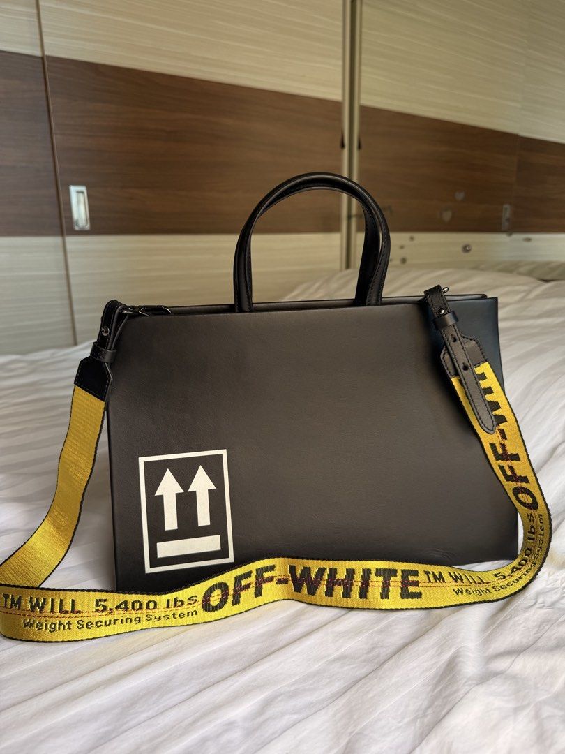 Authentic OFF WHITE Sculpture Leather Tote Bag Black (Category: Tote Bags) located in Taguig. Submitted by _annaq_ (Listing ID 1466376008, Image 2). Description: - Brand: Off-White - Color: Black with iconic white 'Sculpture' lettering on front and arrows graphic on the back - Material: Premium leather with fabric inner lining and interior main label print - Hardware: Heavy-duty hardware with the signature removable yellow industrial strap - Desi