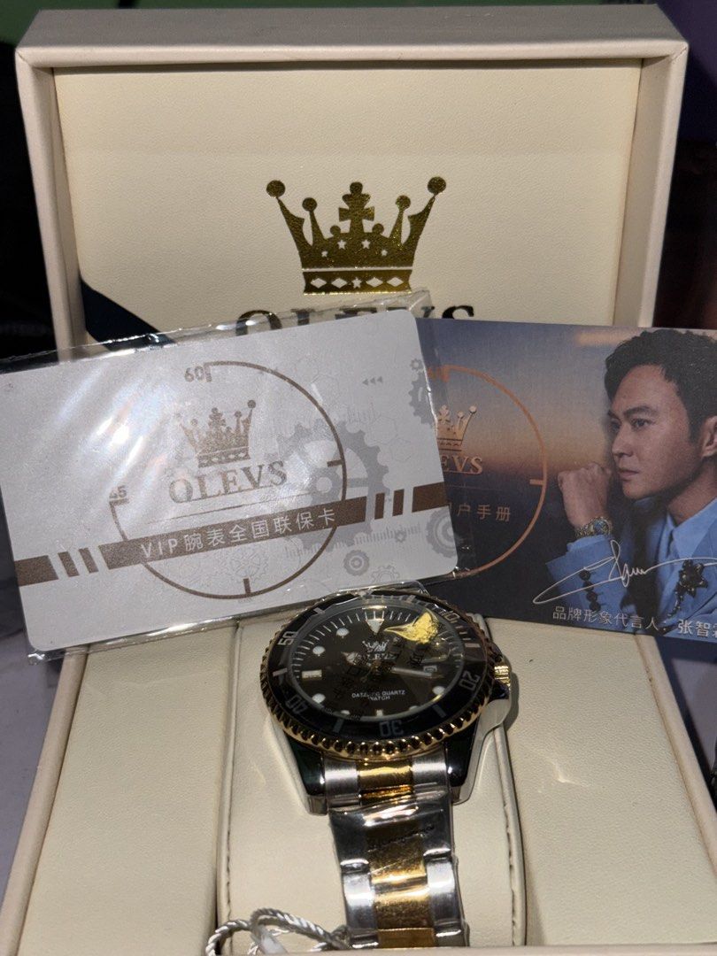 Olevs Dazzling Quartz Watch Gold Silver Two Tone (Category: Women's Watches) located in Paranaque City. Submitted by annann128 (Listing ID 1466560989, Image 2). Description: - Brand: Olevs Quartz Watch - Colorway: Black, Gold, and Silver - Condition: Brand new, unworn, with factory plastics still attached on the bracelet - Features: Rotating bezel and date window at the 3 o'clock position - Strap: Two-tone steel bracelet - Inclusions: Original br