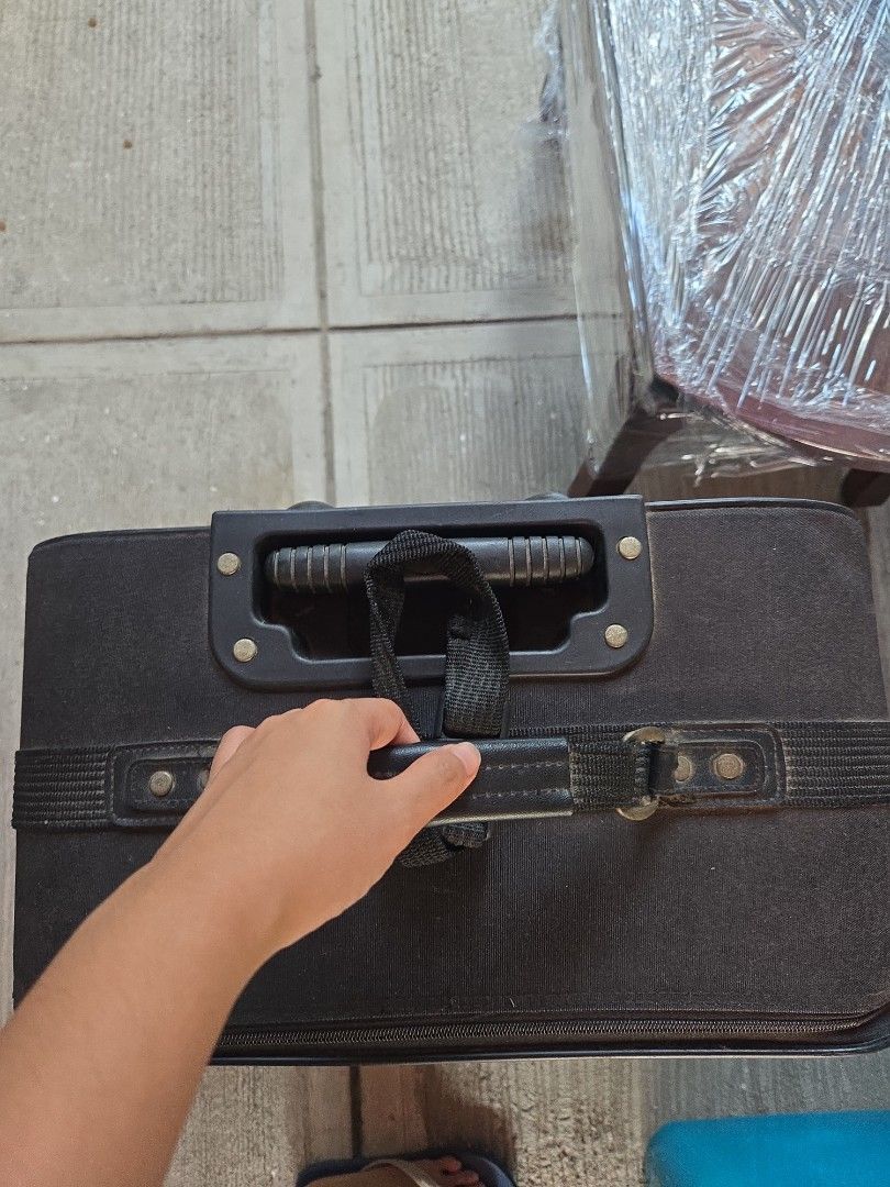 Olympia Black Rolling Suitcase Luggage (Category: Luggage) located in Manila. Submitted by preownedddd (Listing ID 1466344096, Image 2). Description: - Brand: Olympia - Color: Classic black fabric - Mobility: Smooth rolling wheels with a retractable handle - Storage: Multiple exterior zippered pockets for easy access - Durability: Sturdy reinforced corner guards and horizontal support straps - Condition: Clean exterior with minor signs of handlin