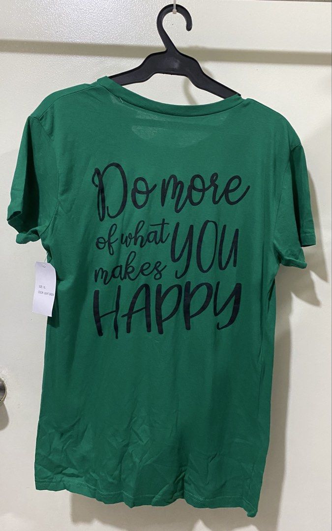 On Fire Be Happy Green Graphic Tee Size XL (Category: Shirts) located in Manila. Submitted by divinemercy_29 (Listing ID 1466464256, Image 2). Description: - Brand: On Fire - Size: Extra Large (XL) - Color: Green - Material: 100% Cotton (machine wash cold, tumble dry low) - Condition: Brand new, unworn with original Ross retail tag ($6.99) - Design: Front reads 'Be happy' in black cursive; back reads 'Do more of what makes YOU HAPPY'.