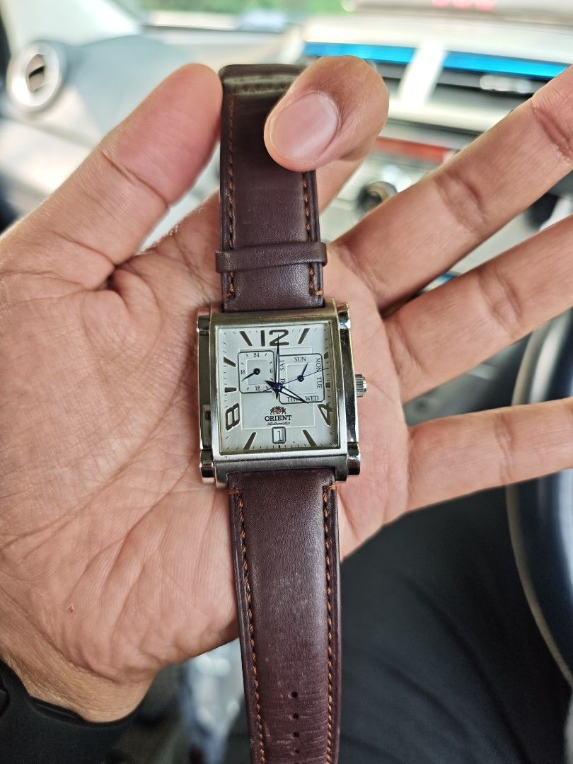 Orient Automatic Rectangular Dial Men's Watch (Category: Watches) located in Kuala Terengganu. Submitted by adibrahman65183 (Listing ID 1466539760, Image 1). Description: Authentic Orient automatic watch with a striking rectangular silver dial, large Arabic numerals, and a dark brown leather strap. Features day, date, and 24-hour sub-dials with 50m water resistance. Note: date needs repair, to be sell as collection.