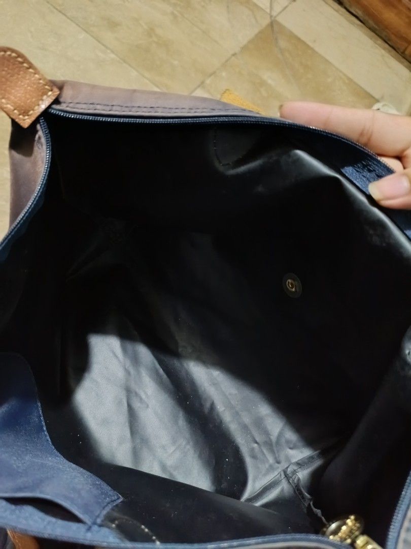 Original Longchamp Le Pliage Navy Blue Tote Bag (Category: Luxury Bags & Wallets) located in Manila. Submitted by rsnnpr24 (Listing ID 1466468284, Image 2). Description: - Authentic Longchamp Le Pliage shoulder bag (Made in France) - Color: Navy blue with brown leather handles and flap - Material: Durable foldable nylon body with gold-tone hardware - Closure: Zip top with iconic jockey medallion pull and snap button - Model details: Interior tag 