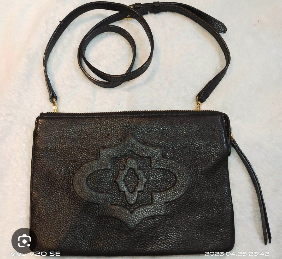 OryanyBlack Leather Crossbody Bag (Category: Cross-body Bags) located in Manila. Submitted by lene48 (Listing ID 1466445396, Image 1). Description: Black textured leather crossbody bag. Front has a distinct debossed geometric medallion design. Top zipper closure with a matching wrist strap on the side. Includes an adjustable, detachable shoulder strap. Inside lining has a printed geometric pattern . Clean interior with a zip pocket..