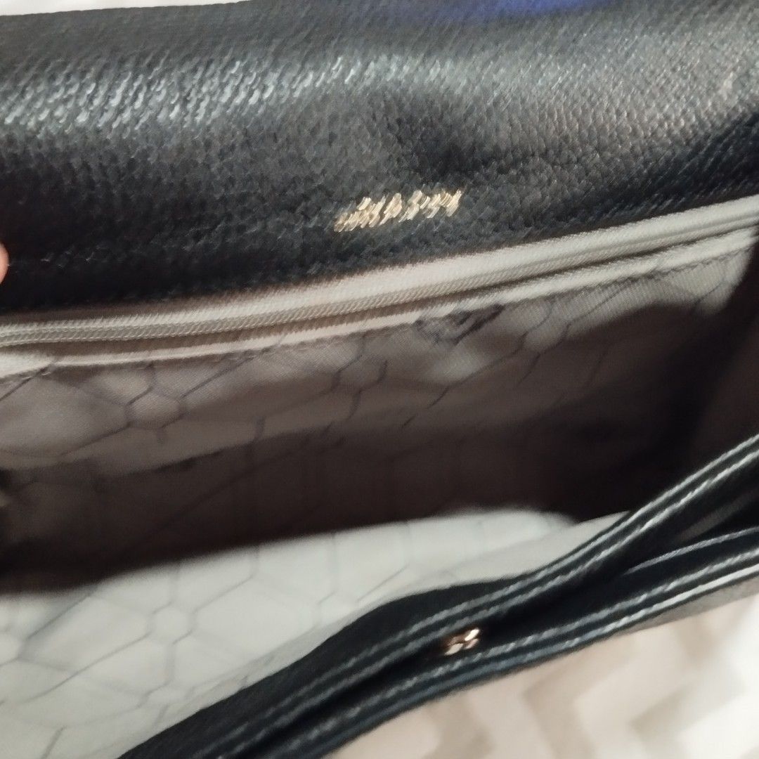 OryanyBlack Leather Crossbody Bag (Category: Cross-body Bags) located in Manila. Submitted by lene48 (Listing ID 1466445396, Image 3). Description: Black textured leather crossbody bag. Front has a distinct debossed geometric medallion design. Top zipper closure with a matching wrist strap on the side. Includes an adjustable, detachable shoulder strap. Inside lining has a printed geometric pattern . Clean interior with a zip pocket..