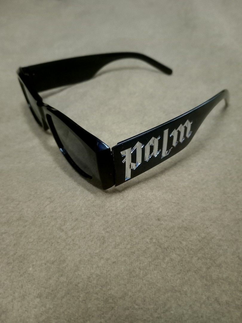 Palm Angels Black Rectangular Sunglasses (Category: Sunglasses & Eyewear) located in Aguinaldo. Submitted by ukayandthrift (Listing ID 1466413243, Image 1). Description: - Brand/Style: Black rectangular sunglasses with thick acetate frames - Details: Bold silver gothic Palm Angels lettering on both temples - Lenses: Dark tinted, zero scratches - Condition: Clean condition, flawless frame and lenses - Vibe: Ultimate accessory for a statement stree