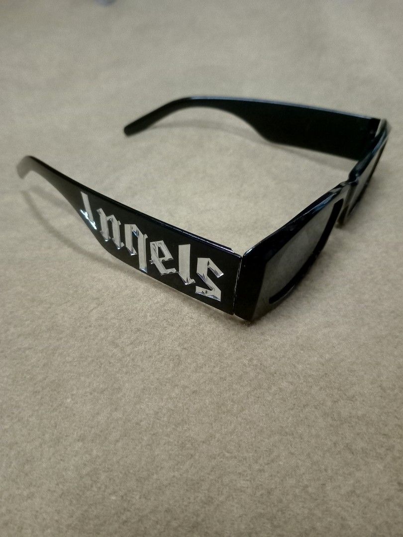 Palm Angels Black Rectangular Sunglasses (Category: Sunglasses & Eyewear) located in Aguinaldo. Submitted by ukayandthrift (Listing ID 1466413243, Image 2). Description: - Brand/Style: Black rectangular sunglasses with thick acetate frames - Details: Bold silver gothic Palm Angels lettering on both temples - Lenses: Dark tinted, zero scratches - Condition: Clean condition, flawless frame and lenses - Vibe: Ultimate accessory for a statement stree