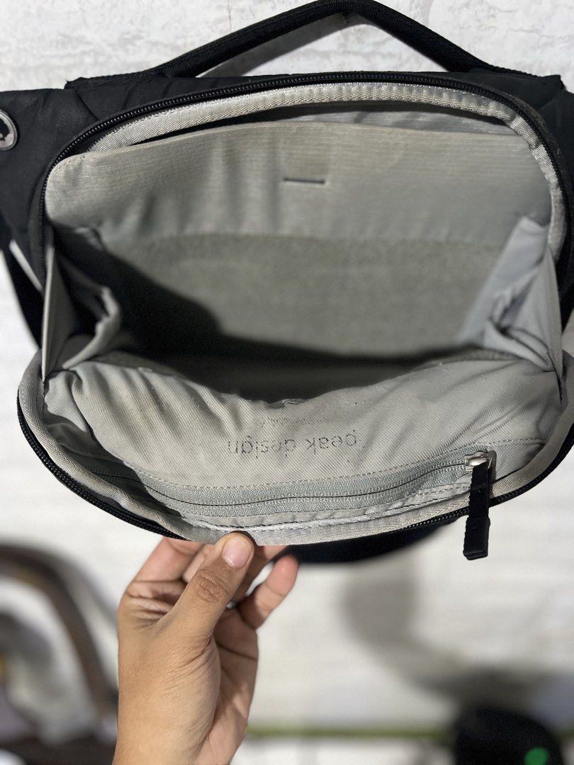 Peak Design Everyday Sling V2 for Black (Category: Camera Bags & Carriers) located in Pasig City. Submitted by Blue92 (Listing ID 1466380091, Image 3). Description: - Brand: Peak Design - Color: Black with grey interior lining - Style: Everyday sling bag - Features: Adjustable strap with signature hardware buckle, interior zippered pocket, front zippered pocket - Condition: Weather-resistant shell shows general surface wear along edges; minor fab
