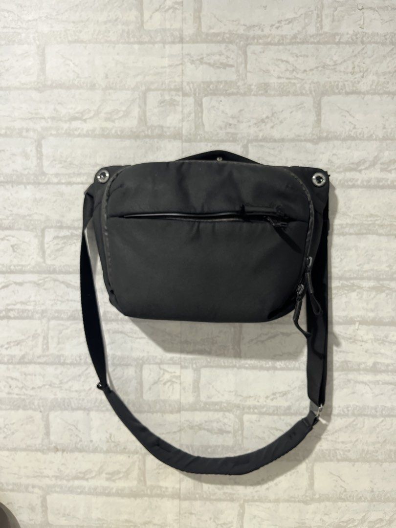 Peak Design Everyday Sling V2 for Black (Category: Camera Bags & Carriers) located in Pasig City. Submitted by Blue92 (Listing ID 1466380091, Image 1). Description: - Brand: Peak Design - Color: Black with grey interior lining - Style: Everyday sling bag - Features: Adjustable strap with signature hardware buckle, interior zippered pocket, front zippered pocket - Condition: Weather-resistant shell shows general surface wear along edges; minor fab