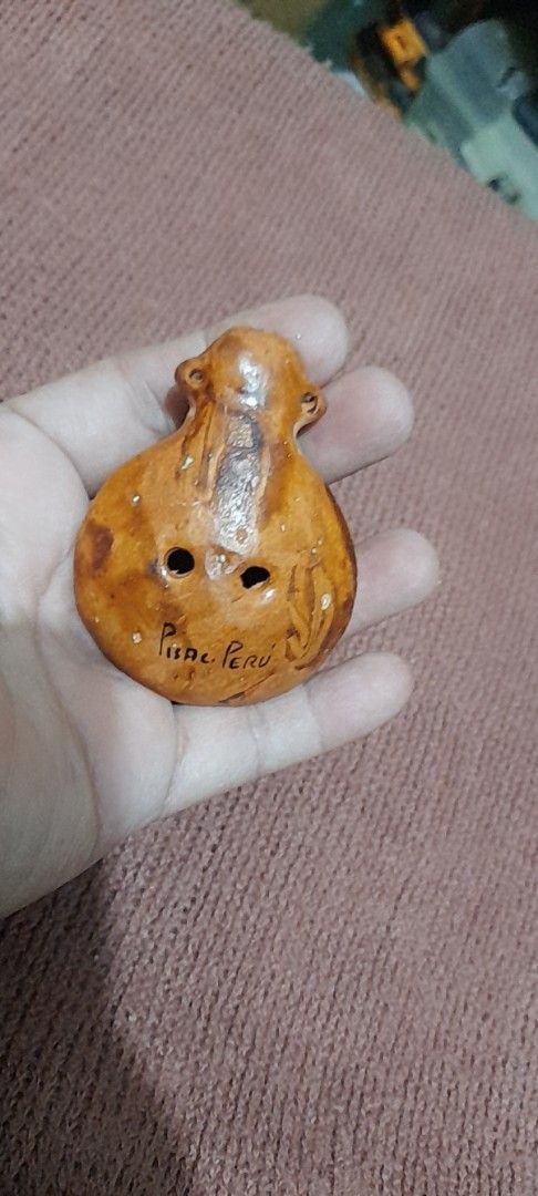 Peruvian Ceramic Ocarina Souvenir Instrument from Pisac (Category: Musical Instruments) located in Bocaue. Submitted by marajapansurplus (Listing ID 1466412074, Image 1). Description: - Authentic handcrafted ceramic ocarina from Pisac, Peru - Features a charming sculpted monkey or animal figure on top - Glazed brownish finish with traditional folk art design - Compact, palm-sized instrument with two finger holes and a functional mouthpiece - Perf