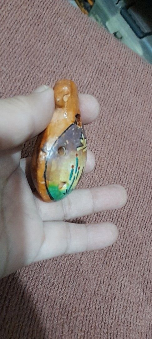 Peruvian Ceramic Ocarina Souvenir Instrument from Pisac (Category: Musical Instruments) located in Bocaue. Submitted by marajapansurplus (Listing ID 1466412074, Image 3). Description: - Authentic handcrafted ceramic ocarina from Pisac, Peru - Features a charming sculpted monkey or animal figure on top - Glazed brownish finish with traditional folk art design - Compact, palm-sized instrument with two finger holes and a functional mouthpiece - Perf