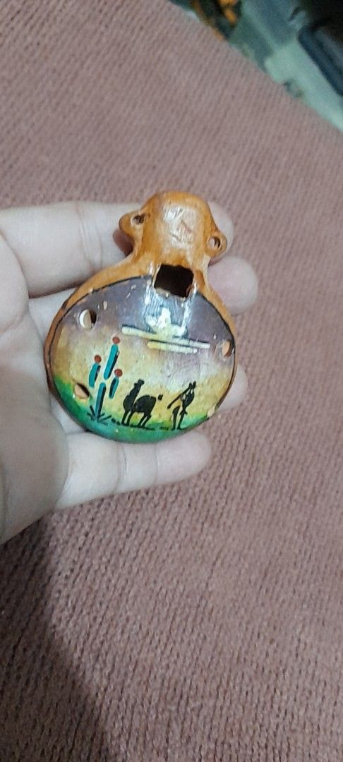 Peruvian Ceramic Ocarina Souvenir Instrument from Pisac (Category: Musical Instruments) located in Bocaue. Submitted by marajapansurplus (Listing ID 1466412074, Image 2). Description: - Authentic handcrafted ceramic ocarina from Pisac, Peru - Features a charming sculpted monkey or animal figure on top - Glazed brownish finish with traditional folk art design - Compact, palm-sized instrument with two finger holes and a functional mouthpiece - Perf