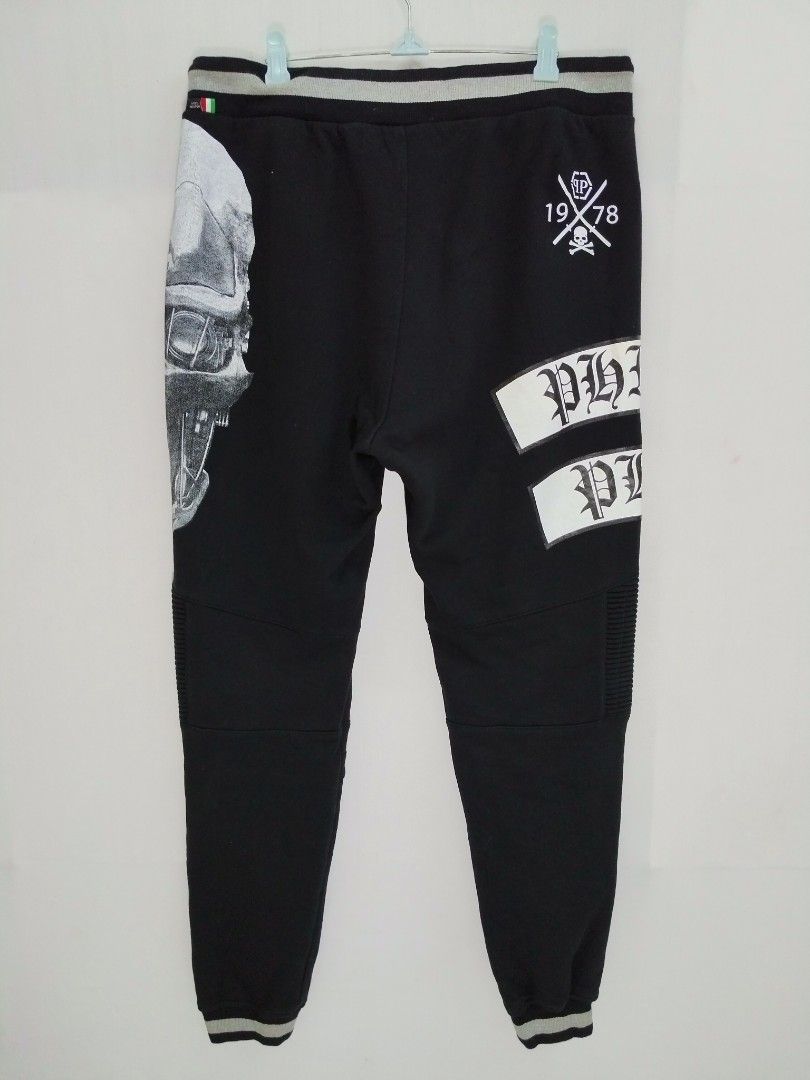 Philipp Plein Skull Joggers Black Size 32-34 (Category: Joggers) located in Davao. Submitted by Mac_koyz (Listing ID 1466447461, Image 2). Description: - Brand: Philipp Plein - Color: Black - Size: 32-34 (Length: 39 inches) - Design: Big crystal skull graphic on front leg with bold white brand lettering - Details: Ribbed biker panels at the knees, striped elastic cuffs, and back skull logo patch (1978) - Hardware: Drawstring waist with custom hex