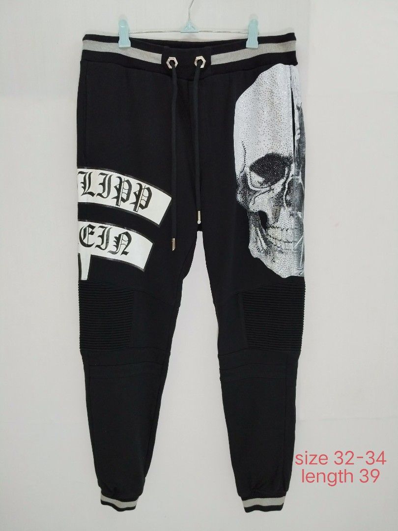 Philipp Plein Skull Joggers Black Size 32-34 (Category: Joggers) located in Davao. Submitted by Mac_koyz (Listing ID 1466447461, Image 1). Description: - Brand: Philipp Plein - Color: Black - Size: 32-34 (Length: 39 inches) - Design: Big crystal skull graphic on front leg with bold white brand lettering - Details: Ribbed biker panels at the knees, striped elastic cuffs, and back skull logo patch (1978) - Hardware: Drawstring waist with custom hex