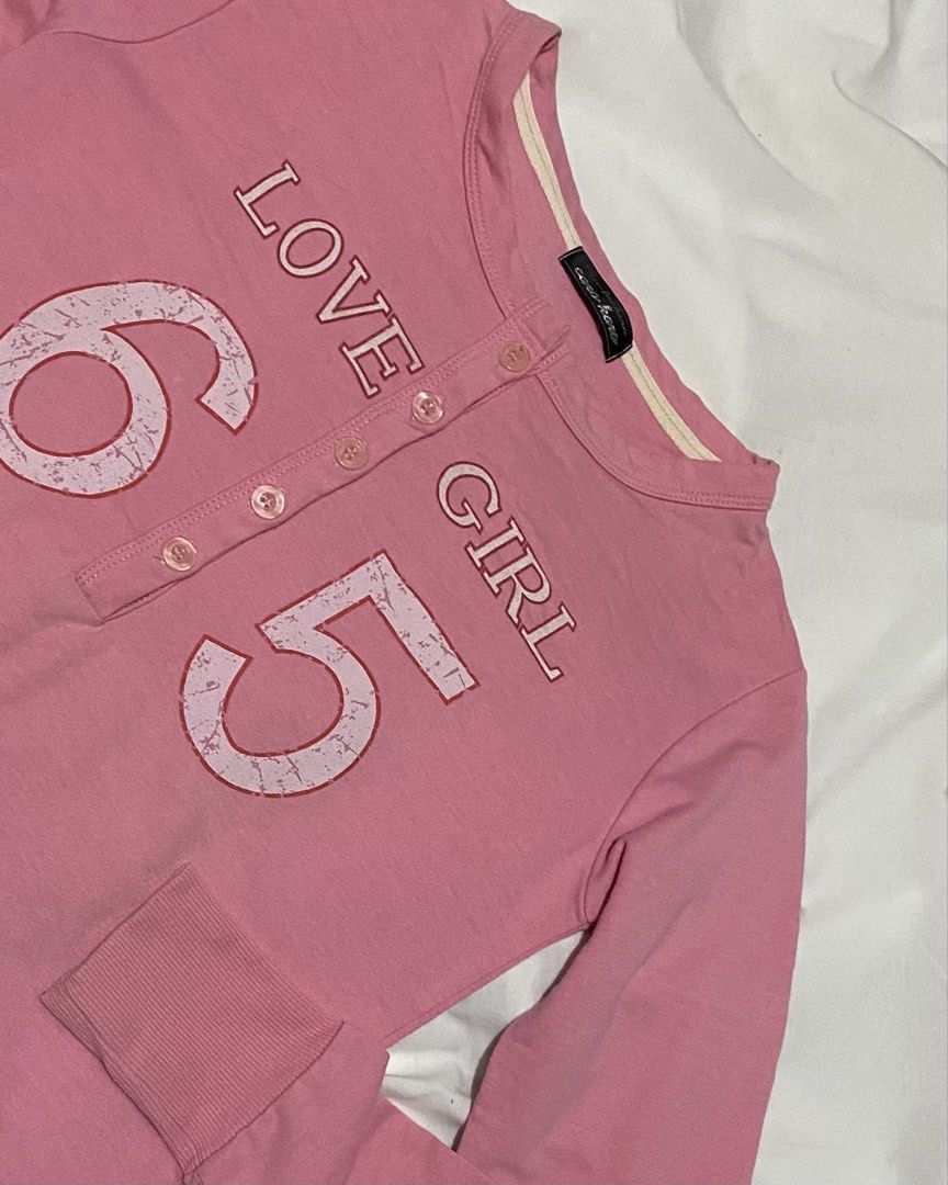 PINK HENLEY GRAPHIC TOP (Category: Longsleeves) located in Pasig City. Submitted by thriftbycelle (Listing ID 1466393236, Image 1). Description: features button front detailing and a distressed vintage "LOVE GIRL 65" graphic print. easy to pair with low-rise jeans, cargo pants, or a pleated skirt! 𐙚 Brand: Coco Hana 𐙚 Size: Fits XS–M — DM for exact flat measurements! 𐙚 Condition: 8.5/10 (intentional distressed print graphic, fabric is soft wit