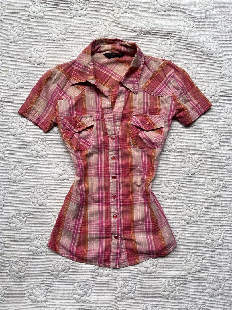 Pink plaid short sleeve button up shirt (Category: Shirts) located in Alabel. Submitted by geragarhea13830 (Listing ID 1466407953, Image 1). Description: - Style: Pink and orange plaid short-sleeve button-up shirt - Fit: Fitted cut, true to size - Details: Classic collar, striking red front buttons, and dual chest pockets with button flaps - Versatility: Perfect casual piece for everyday wear, easily pairs with denim jeans or shorts.