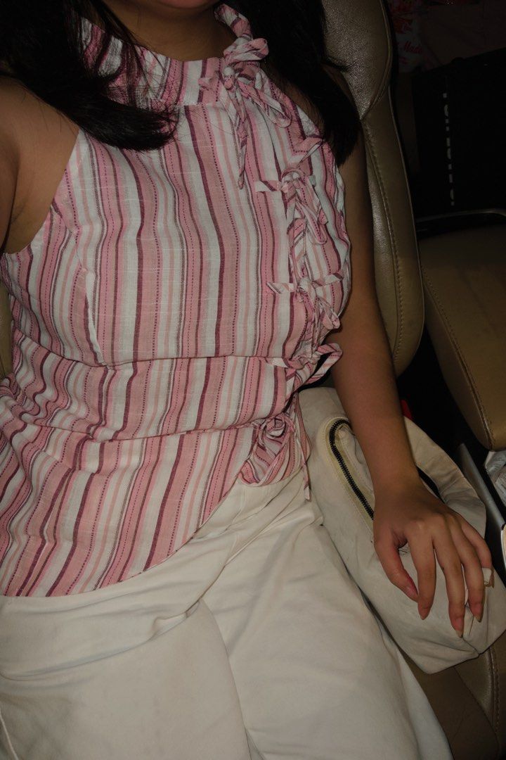 Pink striped halter top with ties (Category: Sleeveless) located in Pateros City. Submitted by jiannaross (Listing ID 1466476084, Image 2). Description: - Color & Pattern: Pink and white vertical stripes - Style: Halter neck with trendy front tie-up closures - Fabric: Lightweight and breathable, ideal for hot weather - Styling: Easily pairs with denim, shorts, or white pants - Condition: Brand new / Excellent (ready to wear).