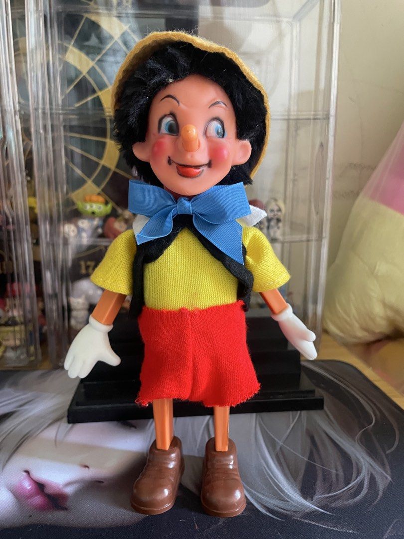 Pinocchio Wind-Up Doll with Hat and Bow (Category: Plushies & Soft Toys) located in Agdangan. Submitted by kuradekawaii_06 (Listing ID 1466561927, Image 1). Description: - WIND UP WORKING - Features iconic details: blue bow tie, yellow hat with red feather, and a wind-up key on the back - Dressed in a yellow shirt, black vest, red shorts, white gloves, and brown shoes - Made with clean fabric clothes and well-painted plastic parts.
