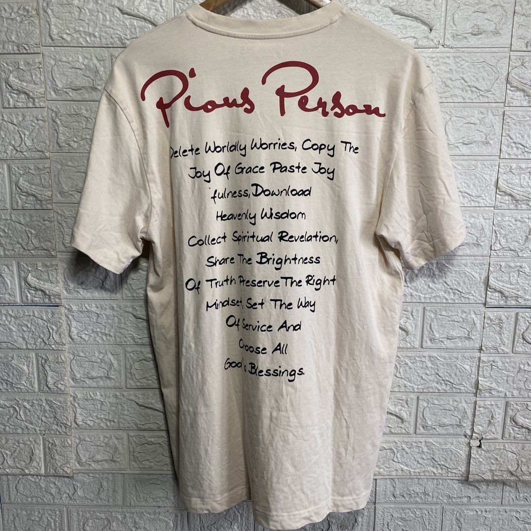 Pious Person Graphic Tee Beige Size M (Category: Tshirts & Polo Shirts ) located in Naga. Submitted by thesource4400 (Listing ID 1466477398, Image 2). Description: - Color: Cream - Style: Short sleeve graphic tee with front and back prints - Front Design: Multi-panel dark art prints with 'Pious Person' in red text - Back Design: Inspirational text layout - Size: Tagged Medium - Measurements: 20.5 inches chest x 29.5 inches length - Material: 100%