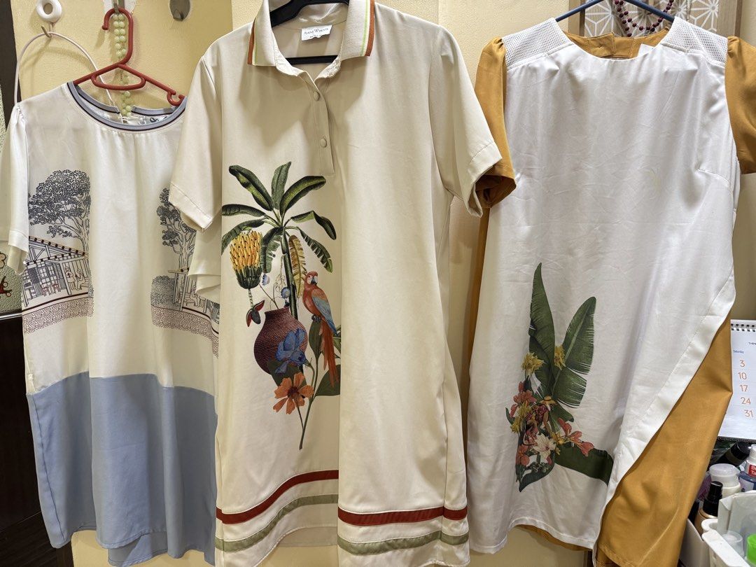 Plains & Prints Take All! Sale!! 3299 (Category: Dresses) located in Iba. Submitted by geliqq (Listing ID 1466392539, Image 1). Description: - Bundle of 3 stylish dresses in clean, ready-to-wear condition - Dress 1: Cream polo dress with vibrant tropical parrot and plant print - Dress 2: White and blue dress featuring chic architectural sketch graphics - Dress 3: White dress with mustard yellow sleeves/side panels and large botanical hem print - 