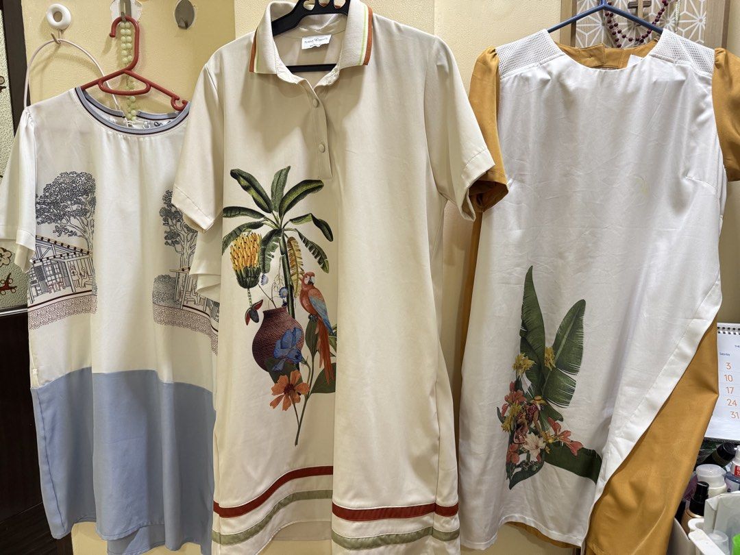 Plains & Prints Take All! Sale!! 3299 (Category: Dresses) located in Iba. Submitted by geliqq (Listing ID 1466392539, Image 2). Description: - Bundle of 3 stylish dresses in clean, ready-to-wear condition - Dress 1: Cream polo dress with vibrant tropical parrot and plant print - Dress 2: White and blue dress featuring chic architectural sketch graphics - Dress 3: White dress with mustard yellow sleeves/side panels and large botanical hem print - 