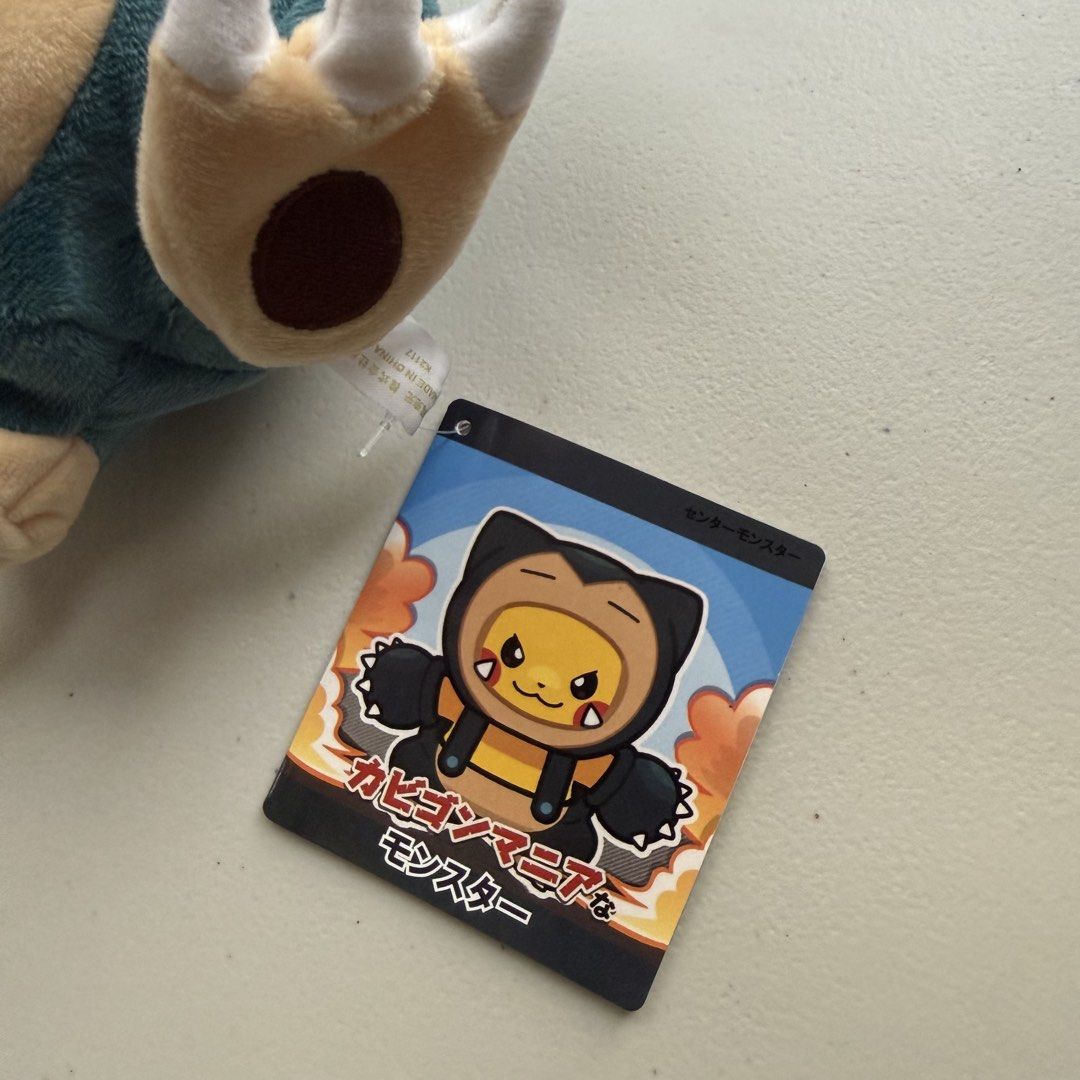 Pokémon Pikachu Snorlax Poncho Plush (Category: Plushies & Soft Toys) located in Manila. Submitted by cheemkenn (Listing ID 1466431745, Image 3). Description: - Official Pokémon merchandise with tag still attached - Features Pikachu wearing an adorable Snorlax onesie/poncho - Made with super soft plush material and neat embroidered facial details - Comes with a removable hood that zips up at the back, revealing Pikachu's tail - Perfect addition f