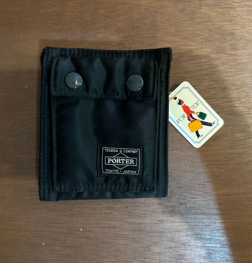 Porter Tanker Wallet Black Yoshida & Co (Category: Luxury Bags & Wallets) located in San Juan City. Submitted by looneyc (Listing ID 1466399126, Image 2). Description: - Brand: Yoshida & Co. Porter (Tanker Series) - Material: Durable black nylon - Condition: Brand new with original tag attached - Origin: Made in Japan - Exterior: Dual snap pockets on the front - Interior: Card slots, zippered coin pouch, and attached key ring with signature orang