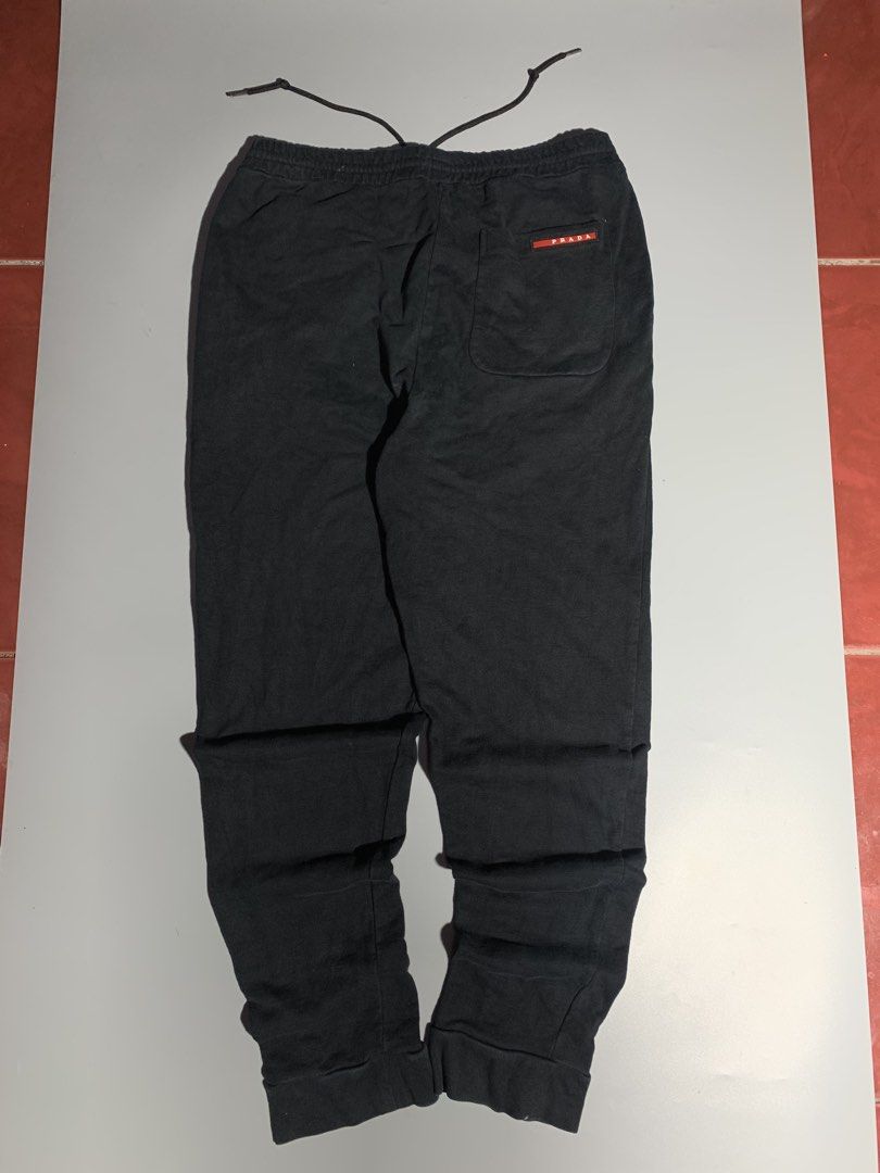 Prada Black Joggers Sweatpants with Red Logo (Category: Joggers) located in Bulacan. Submitted by aaron_garrucho15 (Listing ID 1466379441, Image 1). Description: - black Prada sweatpants - Soft, comfortable cotton material with a relaxed fit - Adjustable drawstring waistband for a custom fit - Ribbed cuffs at the ankles - Two functional side pockets and one rear pocket - Features the iconic red Prada logo tag - Great for daily casual wear or loun