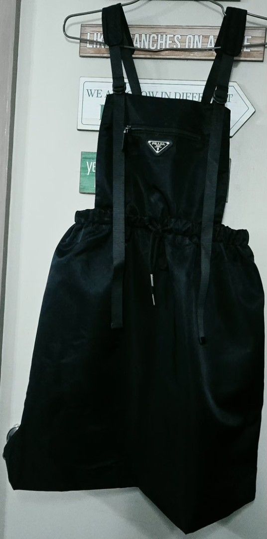 Prada Black Nylon Mini Camisole Dress (Category: Dresses) located in Manila. Submitted by ubasirene (Listing ID 1466375992, Image 2). Description: - Designer camisole dress by Prada, made in Romania - Color: Classic black - Material: 100% polyamide outer with 100% viscose lining - Design: Stylish cowl neck, dropped waistline, and adjustable shoulder straps - Features: Front zipper pocket accented with the iconic Prada metal logo triangle - Fit: E