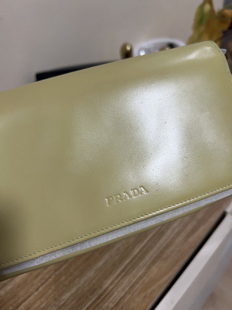 Prada Milano Long Wallet in Yellow with Box (Category: Luxury Bags & Wallets) located in Cauayan City . Submitted by best_buyph_88 (Listing ID 1466358853, Image 2). Description: - Brand: Prada Milano (Made in Italy) - Material: Smooth leather in pastel yellow - Closure: Double snap button flap - Interior: Multiple card slots, compartments, and zippered coin l pop - Inclusions: Original textured black Prada presentation box - Condition: Excellent 