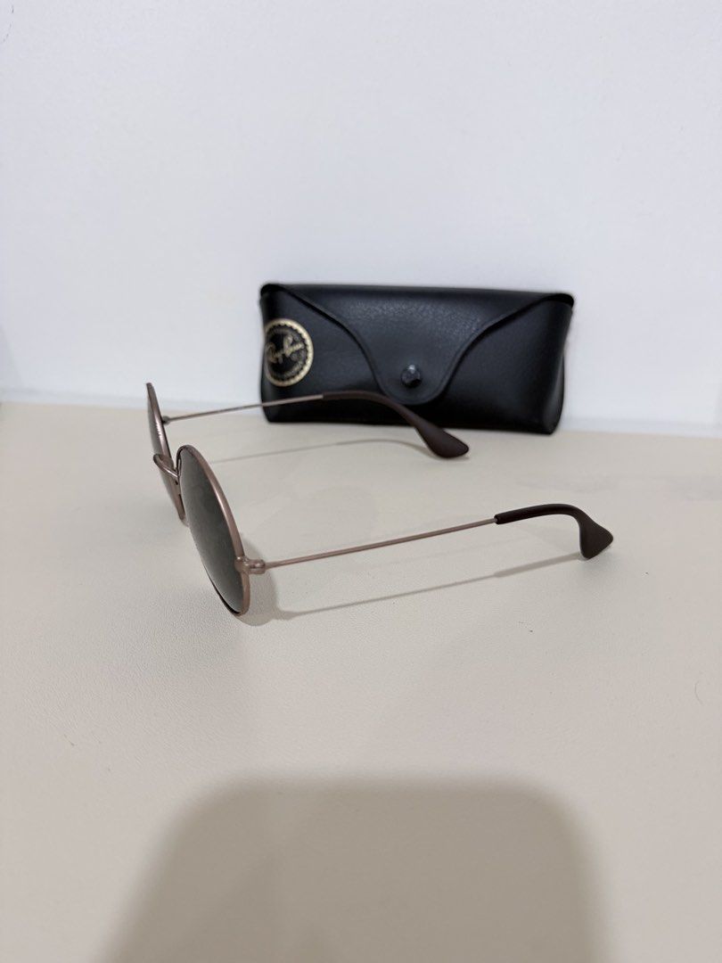 Ray-Ban Round Metal Sunglasses with Case (Category: Sunglasses & Eyewear) located in Manila. Submitted by prelovedbymycam (Listing ID 1466350520, Image 3). Description: - Brand: Ray-Ban - Style: Round metal sunglasses with thin gold-tone frames and dark lenses - Details: Dark brown temple tips, classic everyday style - Inclusion: Original black leatherette hard case with Ray-Ban logo stamp.