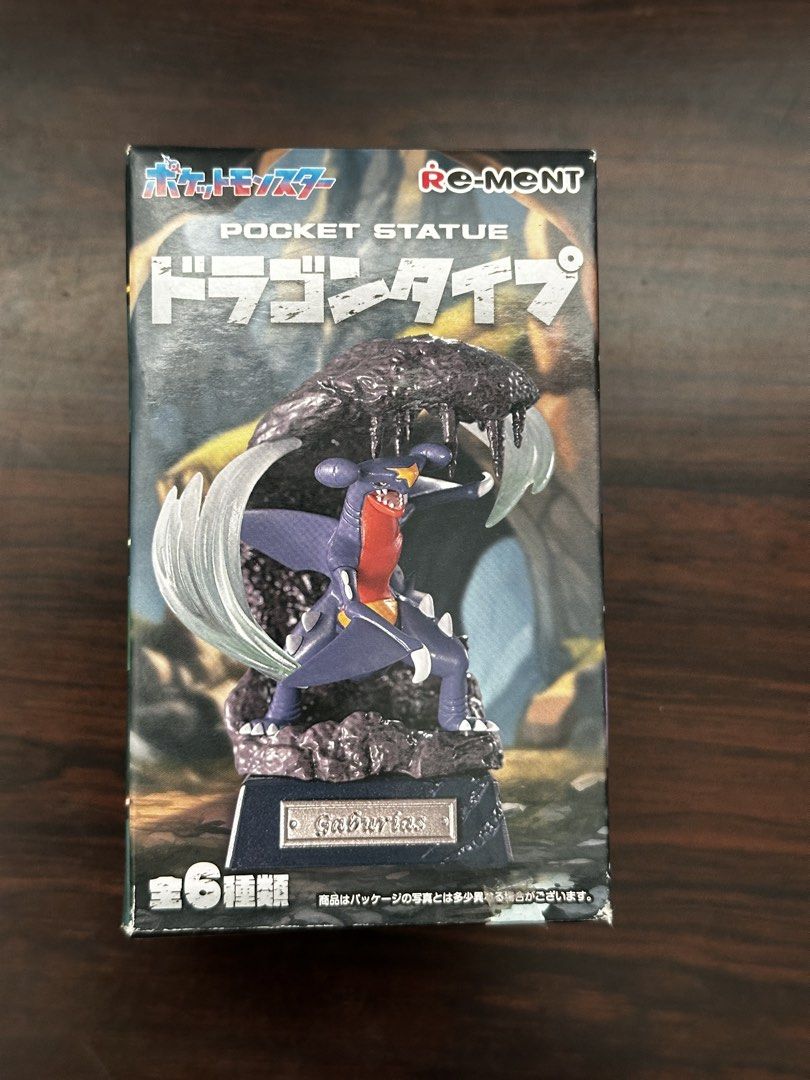 Re-Ment Pokémon Pocket Statue Dragon Type Dragapult (Category: Figurines & Statues) located in Cavite. Submitted by debbieafrica (Listing ID 1466431385, Image 1). Description: - Brand: Re-Ment Pokémon Pocket Statue - Series: Dragon Type (Box #4 - Garchomp) - Condition: Brand new, unopened blind box - Features detailed Garchomp figure inside - Outer box shows full 6-figure collection (Dragonite, Flygon, Salamence, Goodra, Dragapult, Garchomp) - 10