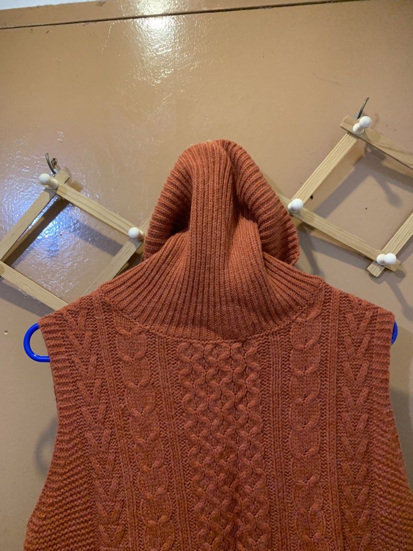Rust Orange Turtleneck Knit Sweater Vest (Category: Sleeveless) located in Las Pinas. Submitted by mscandicestarry (Listing ID 1466466942, Image 3). Description: - Color: Rust orange - Style: Sleeveless chunky turtleneck with cable knit front - Design: Ribbed armholes/hem, high-low hemline with split sides - Fabric: Soft, textured knit with great stretch - Best for: Autumn and winter layering outfits.