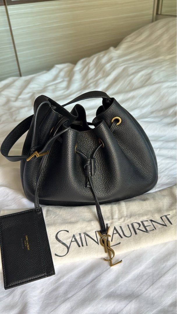 Authentic Saint Laurent Black Leather Bucket Bag (Category: Luxury Bags & Wallets) located in Taguig. Submitted by _annaq_ (Listing ID 1466384966, Image 3). Description: - Authentic Saint Laurent bucket bag in black grained leather - Elegant gold-tone hardware throughout - Adjustable shoulder strap for comfortable wear - Secure drawstring closure accented with iconic YSL metal charm - Clean interior featuring a handy slip pocket - Includes matchi