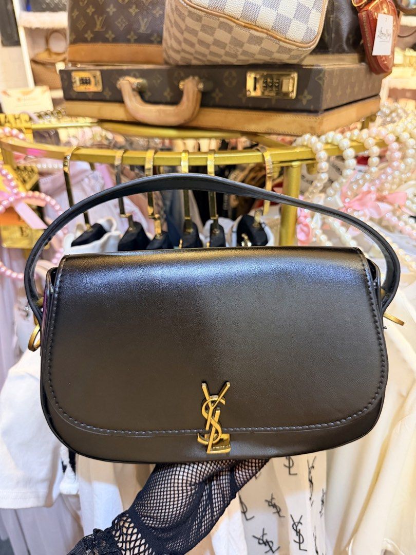 Saint Laurent YSL Black Leather Shoulder Bag (Category: Luxury Bags & Wallets) located in Dumaguete. Submitted by lovebags.ph (Listing ID 1466394744, Image 3). Description: - Brand: Saint Laurent - Material: Premium smooth leather in classic black - Hardware: Signature gold-tone YSL monogram and side attachments - Design: Structured rectangular shape with rounded bottom corners and tonal stitching - Features: Matching top handle and optional stra