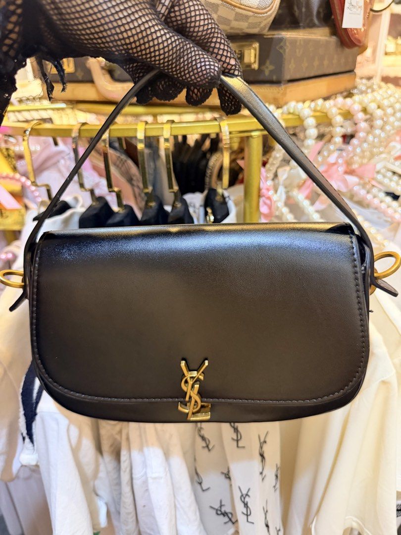 Saint Laurent YSL Black Leather Shoulder Bag (Category: Luxury Bags & Wallets) located in Dumaguete. Submitted by lovebags.ph (Listing ID 1466394744, Image 2). Description: - Brand: Saint Laurent - Material: Premium smooth leather in classic black - Hardware: Signature gold-tone YSL monogram and side attachments - Design: Structured rectangular shape with rounded bottom corners and tonal stitching - Features: Matching top handle and optional stra