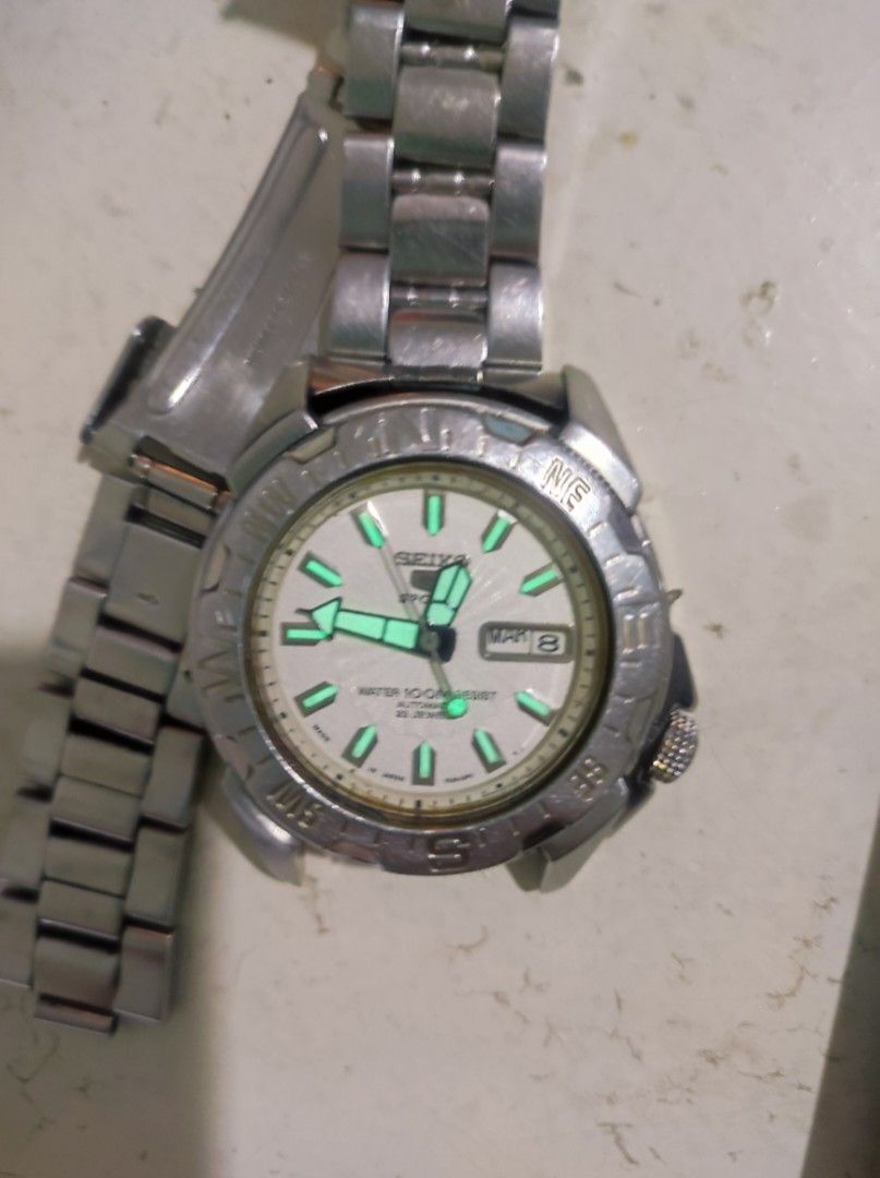 Seiko 5 Sports Automatic Compass Bezel Watch (Category: Men's Watches) located in Pasay City. Submitted by wizemindz138970 (Listing ID 1465647828, Image 1). Description: - Brand: Seiko 5 Sports Automatic Watch - Dial: White textured dial with day-date window at 3 o'clock - Movement: 23 jewels automatic movement with exhibition case back - Build: Stainless steel case and matching bracelet - Features: Rotating compass bezel and bright luminous hand