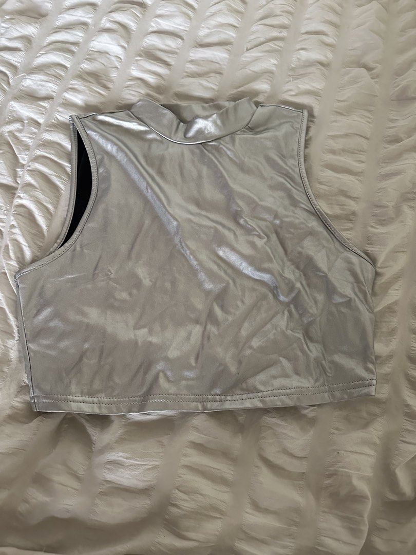 Shein Metallic Silver Mock Neck Crop Top Size L (Category: Sleeveless) located in Mandaluyong City. Submitted by youarecutejeans (Listing ID 1466441892, Image 1). Description: - Brand: Shein - Style: Mock neck, sleeveless crop top with bold futuristic look - Color: Shiny metallic silver with black interior lining - Size: L (EU 40/42, US 8/10) - Occasion: Perfect for parties, music festivals, and clubbing.
