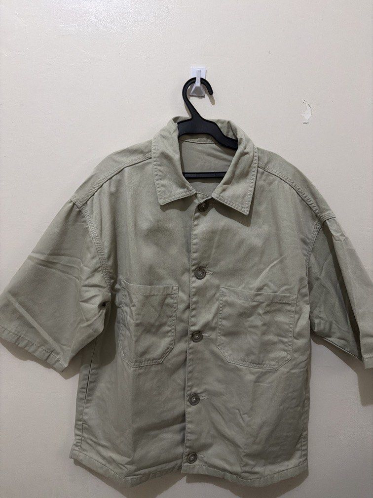 Short Sleeve Button Up Work Shirt Khaki (Category: Tshirts & Polo Shirts ) located in Makati City. Submitted by renzzee (Listing ID 1466475615, Image 2). Description: - Color: Khaki - Style: Utility short sleeve button-up with dark brown buttons - Fit: Relaxed fit with dropped shoulders - Details: Two functional front chest pockets - Material: Sturdy fabric, perfect for everyday layering.