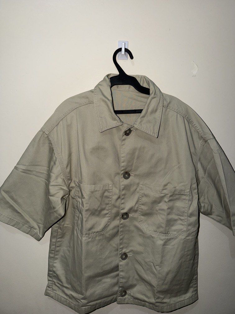 Short Sleeve Button Up Work Shirt Khaki (Category: Tshirts & Polo Shirts ) located in Makati City. Submitted by renzzee (Listing ID 1466475615, Image 1). Description: - Color: Khaki - Style: Utility short sleeve button-up with dark brown buttons - Fit: Relaxed fit with dropped shoulders - Details: Two functional front chest pockets - Material: Sturdy fabric, perfect for everyday layering.