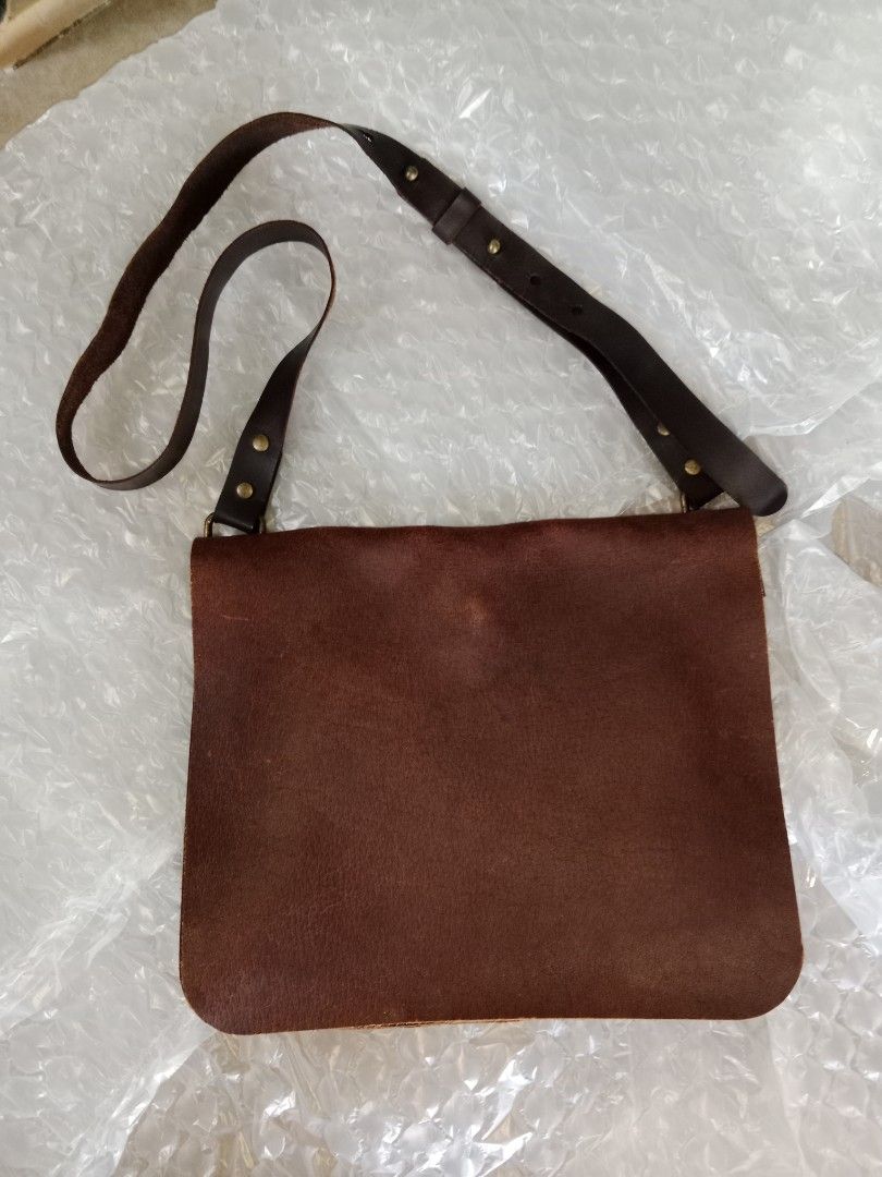 Sling bag - Bags by Rubbertree Leather - secondhand (Category: Luxury Bags & Wallets) located in Bayambang. Submitted by lucky_faststar_74a229 (Listing ID 1459569434, Image 1). Description: Chocolate brown textured leather body paired with a durable, adjustable dark brown leather shoulder strap and premium brass hardware. Dimensions: 30cm (L) × 13cm (W) × 24cm (H) Condition: The structure is intact, and the leather has been well-maintained. Shows