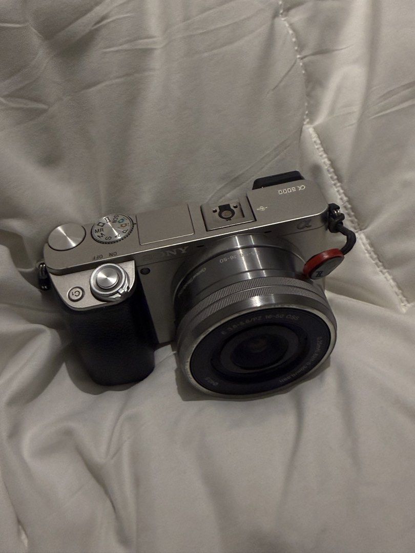 Sony A6000 Mirrorless Camera Bundle with Three Lenses (Category: Cameras) located in Manila. Submitted by pjaguilar436945 (Listing ID 1466506978, Image 3). Description: - Camera: Sony A6000 silver body with Peak Design anchor link on right strap lug - Lenses included: E 3.5-5.6/16-50mm OSS power zoom, and a silver telephoto zoom lens with hood - Modes: Standard PASM, memory recall, auto modes, and scene settings - Ideal for: Photo and video creat