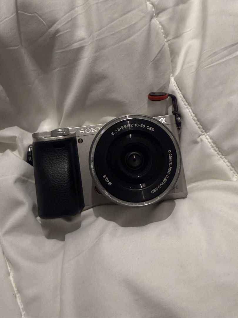 Sony A6000 Mirrorless Camera Bundle with Three Lenses (Category: Cameras) located in Manila. Submitted by pjaguilar436945 (Listing ID 1466506978, Image 1). Description: - Camera: Sony A6000 silver body with Peak Design anchor link on right strap lug - Lenses included: E 3.5-5.6/16-50mm OSS power zoom, and a silver telephoto zoom lens with hood - Modes: Standard PASM, memory recall, auto modes, and scene settings - Ideal for: Photo and video creat
