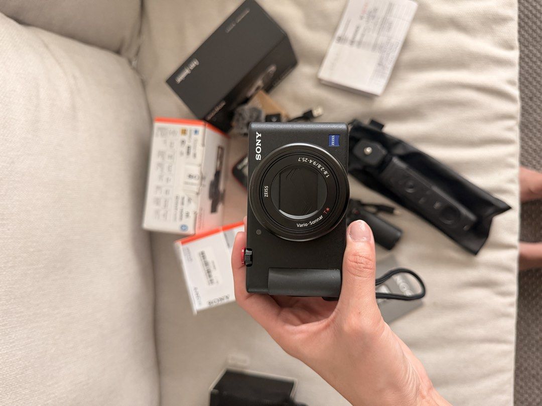 Sony ZV-1 Vlogging Camera Bundle with Shooting Grip and Accessories (Category: Cameras) located in Makati City. Submitted by chamhm (Listing ID 1466405296, Image 2). Description: - Complete vlogging setup: Sony ZV-1 camera with original boxes - Power & Charging: 3 Extra batteries and a convenient dual charger included - Lighting & Audio: Godox flash and a mini microphone for better content - Stabilization: Includes both a JJC shooting grip and a 