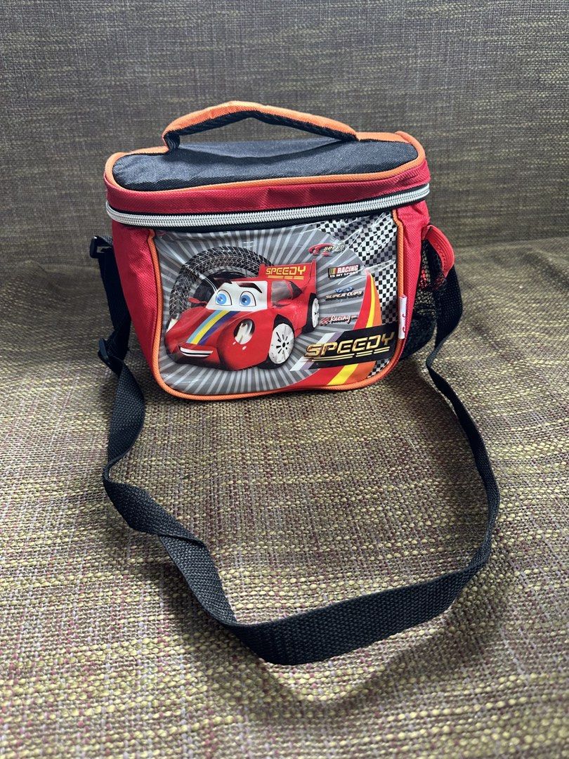 Speedy Racing Car Lunch Bag with Strap (Category: Tote Bags) located in Pasay City. Submitted by kimverlygo50697 (Listing ID 1466401135, Image 2). Description: - Design: Cool red and black with a racing car graphic and 'Speedy' text - Insulation: White insulated lining to keep food warm or cool - Storage: Side mesh pocket for water bottles or small items - Closure: Secure all-around zipper closure - Portability: Includes a sturdy top handle and a
