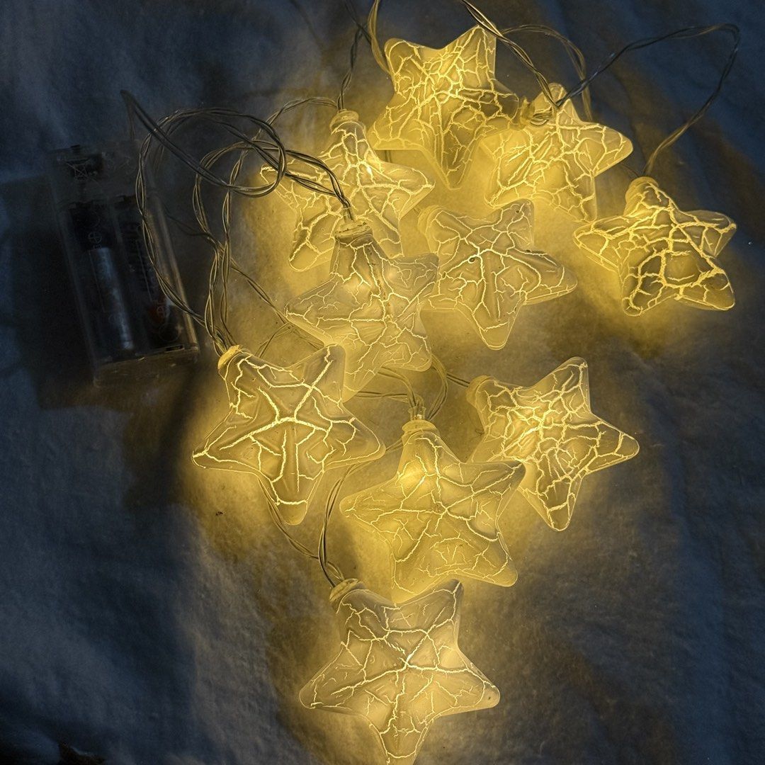 Starry string lights with crackle design and battery pack (Category: Lighting) located in Marikina City. Submitted by lovegoeson (Listing ID 1466484027, Image 1). Description: - Star-shaped LED fairy lights with a unique crackled texture - Emits a cozy warm yellow glow - Battery-operated (takes 2 AA batteries, included) - Discreet transparent wire for a seamless look - Tested and working, ready to hang - Great for bedroom decor, study desks, or h