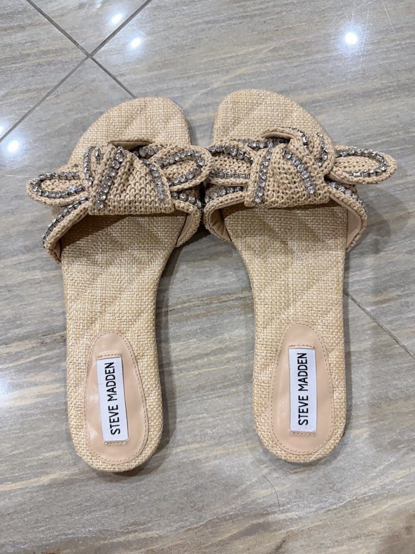 Steve Madden Raffia Rhinestone Bow Slide Sandals Beige (Category: Flats & Sandals) located in Taytay. Submitted by gvccloset (Listing ID 1466449175, Image 3). Description: - Brand: Steve Madden - Style: Slip-on flat sandals - Material: Raffia straw texture - Details: Chic knotted bow with shiny rhinestone embellishments - Color: Neutral beige / light nude - Condition: Great for warm weather, beach days, and casual outings - Bought in US, no box.