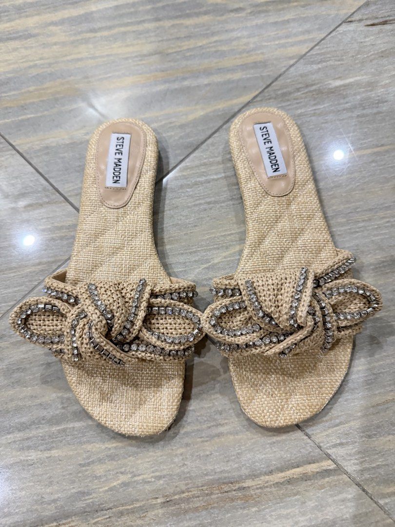 Steve Madden Raffia Rhinestone Bow Slide Sandals Beige (Category: Flats & Sandals) located in Taytay. Submitted by gvccloset (Listing ID 1466449175, Image 1). Description: - Brand: Steve Madden - Style: Slip-on flat sandals - Material: Raffia straw texture - Details: Chic knotted bow with shiny rhinestone embellishments - Color: Neutral beige / light nude - Condition: Great for warm weather, beach days, and casual outings - Bought in US, no box.