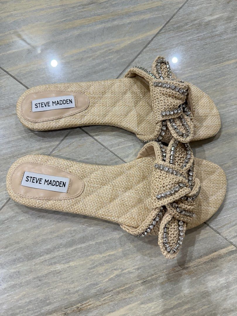 Steve Madden Raffia Rhinestone Bow Slide Sandals Beige (Category: Flats & Sandals) located in Taytay. Submitted by gvccloset (Listing ID 1466449175, Image 2). Description: - Brand: Steve Madden - Style: Slip-on flat sandals - Material: Raffia straw texture - Details: Chic knotted bow with shiny rhinestone embellishments - Color: Neutral beige / light nude - Condition: Great for warm weather, beach days, and casual outings - Bought in US, no box.